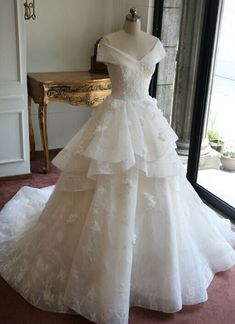 a wedding dress on display in front of a window