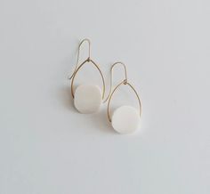 White bone beads on hand-shaped brass arches with brass ear hooks. (1” x 1.75”) Bone Color Dangle Earrings With Ear Wire, White Drop Earrings With French Hook, White Teardrop Earrings With French Hook, Minimalist White Earrings With French Hook, White Minimalist French Hook Earrings, Oval White Brass Jewelry, Minimalist White French Hook Earrings, White Oval Minimalist Earrings, Minimalist White Oval Earrings