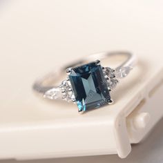 All HANDMADE ITEMS SHIP IN APPROX 8 DAYS Main Stone: Genuine London blue topaz Main Stone Size: Emerald cut 6 mm x 8 mm Main Stone Weight: 2.06 carat Side Stone: CZs Height From The Ring Setting Bottom(to gemstone top): about 5.13 mm Width of Ring band Measure: gradually varied,about 1.67 to 1.91 mm Material: .925 Sterling Silver/14K White Gold/14K Yellow Gold/14k Rose Gold Engraved: Available For FreeNo more than 13 letters) Customized:Of course! Tell me what you want Includes With Order: All o Gift Blue Topaz Ring With Rectangular Shape, Gift Blue Topaz Rectangular Ring, White Gold Emerald-cut Topaz Birthstone Ring, Emerald Cut White Gold Topaz Birthstone Ring, Modern Rectangular Topaz Wedding Ring, Rectangular Topaz Ring With Accent Stones For Anniversary, Rectangular Blue Topaz Ring With Prong Setting, Anniversary Rectangular Topaz Ring With Accent Stones, Anniversary White Gold Topaz Ring With Rectangular Stone