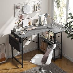 a desk with a chair, laptop and other items on it in front of a window