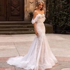 a woman in a wedding dress standing outside