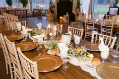 a table set with gold plates and silverware for an elegant wedding reception at the lodge