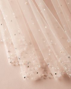 the back of a wedding dress with sequins on it and sheer tulle