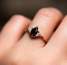 a woman's hand with a black and white diamond ring on top of her finger