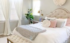 a bedroom with a large bed and chandelier hanging from it's ceiling