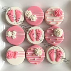 pink and white decorated cookies with baby feet on them