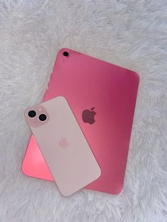 two pink and white iphones sitting next to each other on top of a furry surface