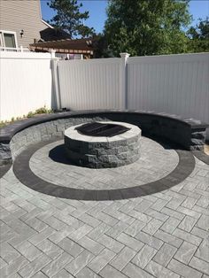 an outdoor fire pit surrounded by a white fence