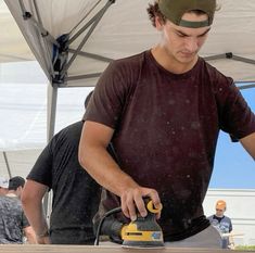 a man is sanding wood with a power tool