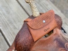 a brown leather glove with a snake head on it and the word denn written in cursive writing