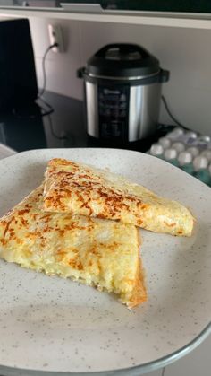 two pieces of food on a plate next to an instant pressure cooker and coffee pot