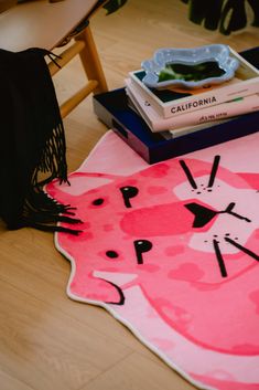 a cat rug on the floor next to some books