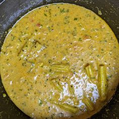 a skillet filled with yellow sauce and green beans