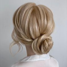 a woman with blonde hair in a low bun