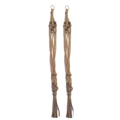 two tall wooden poles with tassels on each end and rope hanging from the ends