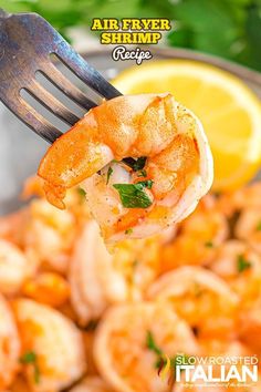 the shrimp is being held up by a fork with lemon wedges and parsley