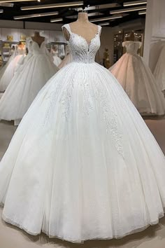 a white ball gown on display in a store with lots of other dresses behind it