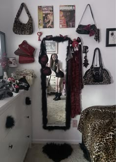 a room with a mirror, leopard print rug and purses on the wall