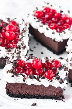 a piece of chocolate cake with cherries and whipped cream in the middle on a white plate