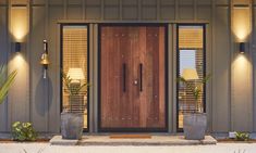 a front door with two planters on either side and one light on above it