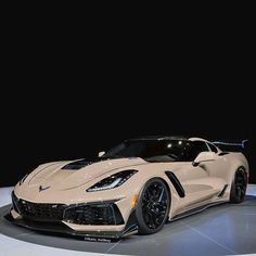 a white sports car on display at an auto show