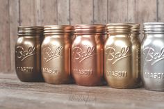 five different colored mason jars lined up on a table