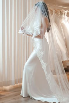 a woman in a wedding dress with a veil over her head