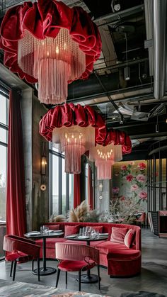 an elegant restaurant with red velvet furniture and chandeliers hanging from the ceiling,