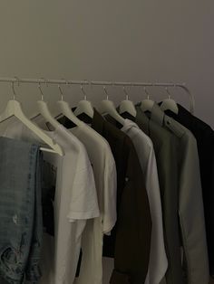 several shirts hanging on clothes racks in a room