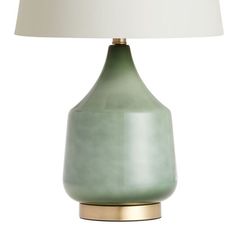 a green table lamp with a white shade on the base and a gold metal base