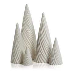 three white vases sitting next to each other on top of a table with wavy lines