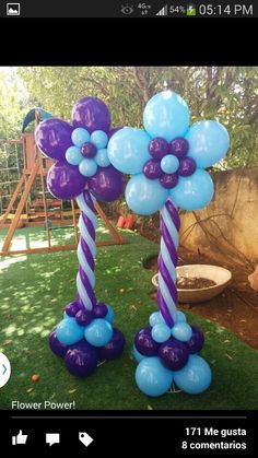 some balloons are in the shape of flowers and one is blue with purple stripes on it