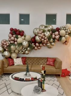 a living room decorated for christmas with balloons and ornaments on the wall, couches and coffee table