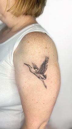 a woman with a bird tattoo on her arm