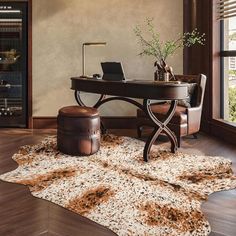 a desk with a laptop on top of it and a rug in front of it