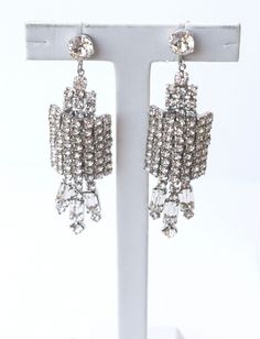 I love these clip-on earrings for their sophisticated and elegant look. They are really unique and  3-dimensional show stoppers. These statement earrings are clip-on earrings but can be converted to post earrings. The earrings have a half barrel sections in the middle giving a sculptural look. They would be a lovely accessory for any bride.  They are large and have a lot of movement.  If you have long hair, these earrings would still show beautifully. All the stones in this piece have been replaced with bright new stones. The earrings measure a little over 3 1/4" long and 7/8" in width.  The rhinestones have all been replace and are in excellent condition, all bright and sparkly. Blue Hair Pins, Bridal Earrings Chandelier, Crystal Earrings Wedding, Gold Earrings Wedding, Rhinestone Hair Pin, Crystal Bridal Earrings, Crystal Hair Pins, Prom Earrings, Vintage Sapphire