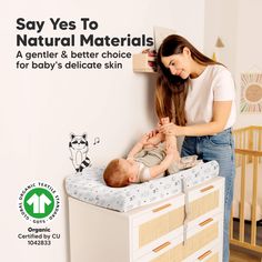 a woman combing a baby's hair while standing next to a dresser with the words say yes to natural materials