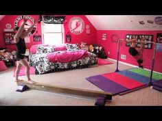 two people doing exercises in a bedroom with pink walls and carpeted flooring, while one person stands on a balance beam