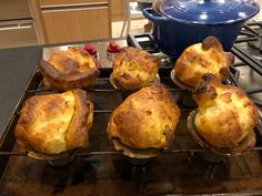 six muffins sitting on top of an oven rack next to a blue pot