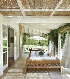 an outdoor living area with wicker furniture and umbrellas