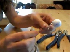 a person holding a remote control over a table with pliers and other tools on it