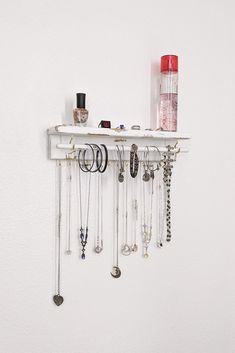 a white shelf filled with lots of necklaces and jewelry hanging from it's sides