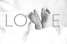 a black and white photo of a baby's feet with the word love above it