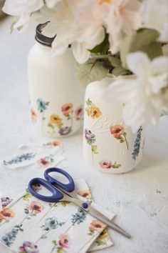 a pair of scissors sitting on top of a table next to flowers