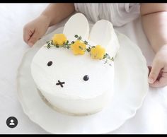 a cake decorated to look like a bunny with yellow flowers on its head and ears