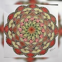 a drawing of a flower with many colors and shapes in the center, on a piece of paper