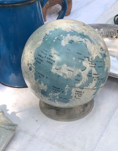 an old blue and white globe sitting on top of a table next to a coffee pot