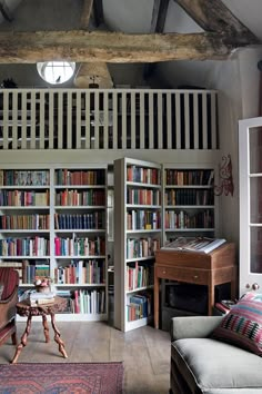 a living room filled with lots of books and furniture