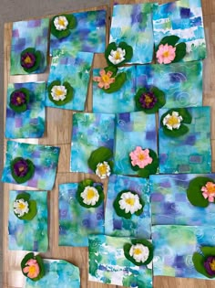 some water lilies are sitting on top of blue paper with white and pink flowers