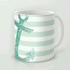 a green and white striped mug with an anchor on it